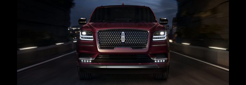 A 2019 Lincoln Navigator driving down a highway at night